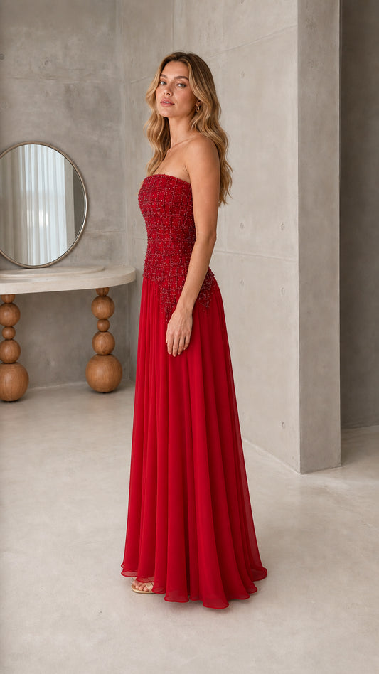 Side profile of model wearing strapless ruby red chiffon evening dress