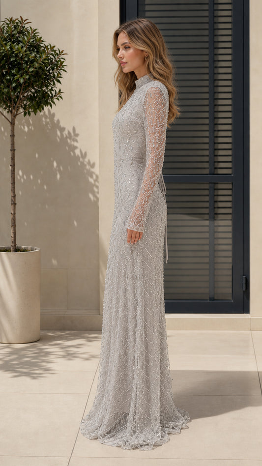 Side profile of model in silver crystal-embellished long sleeve gown