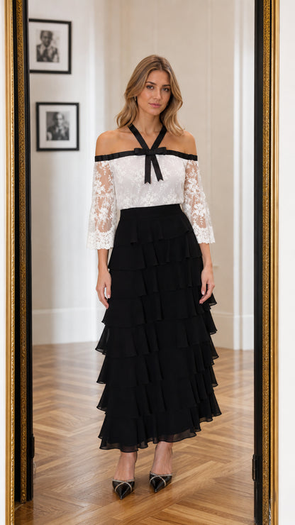 Front view of model wearing white and black off-the-shoulder lace tiered maxi dress