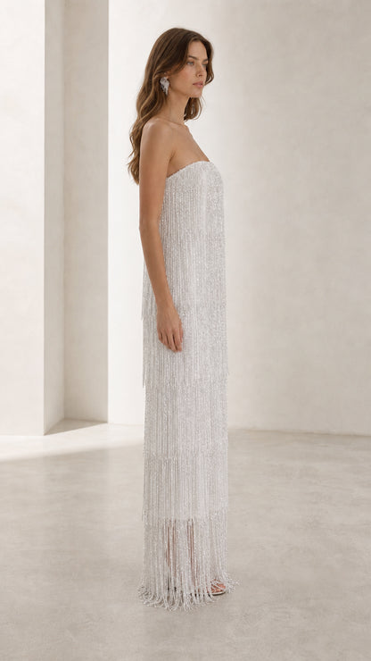 Side profile view of woman in white beaded tassel evening gown