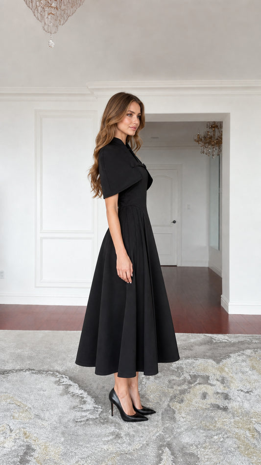 Side profile view of black cape midi dress