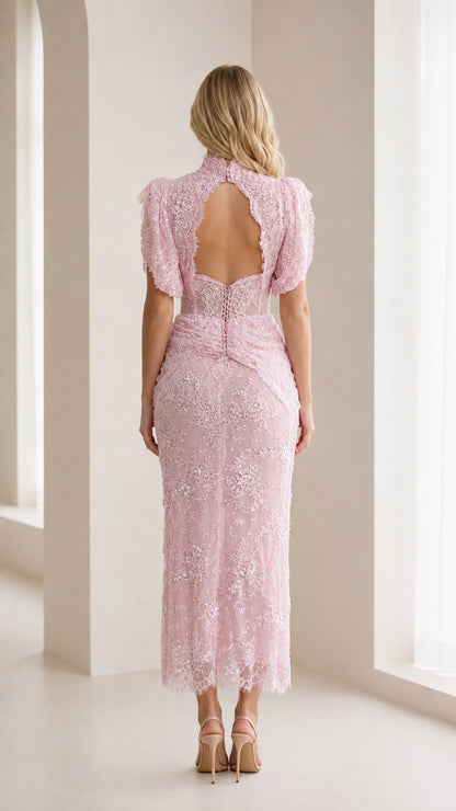 Back view of model showing open back detail of pink lace dress