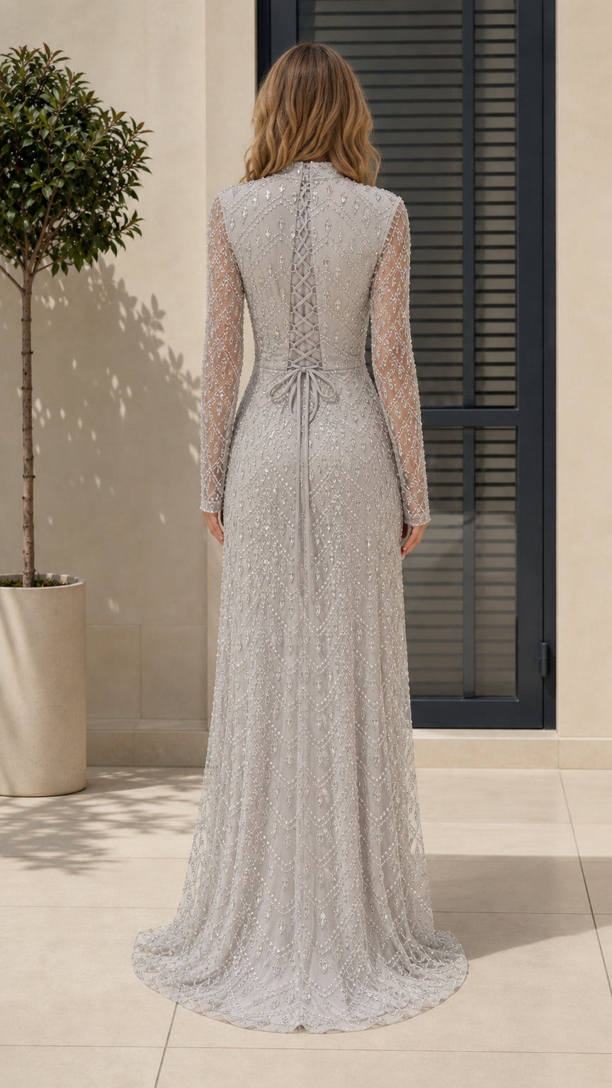 Back view of model showing lace-up detail on silver evening gown