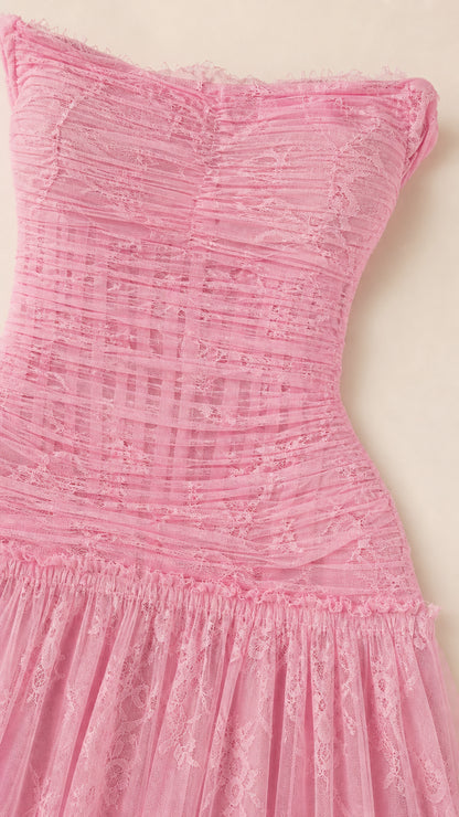 Close-up detail of textured ruching and lace on pink dress