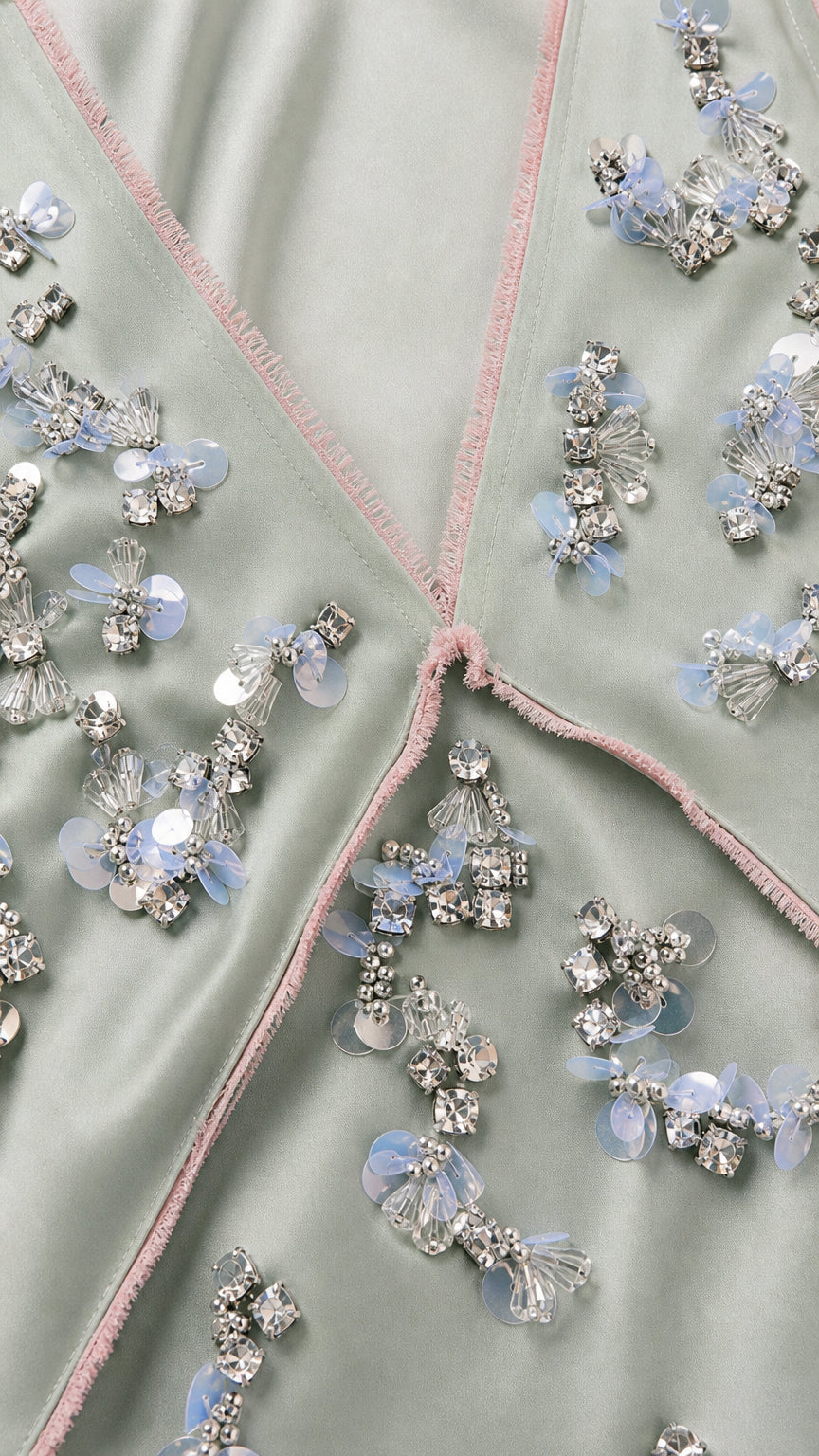 Close-up detail of rhinestone and sequin floral embellishments on sage green dress