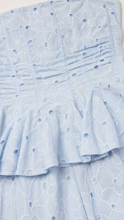 Close-up of fabric texture and peplum waist detail in light blue