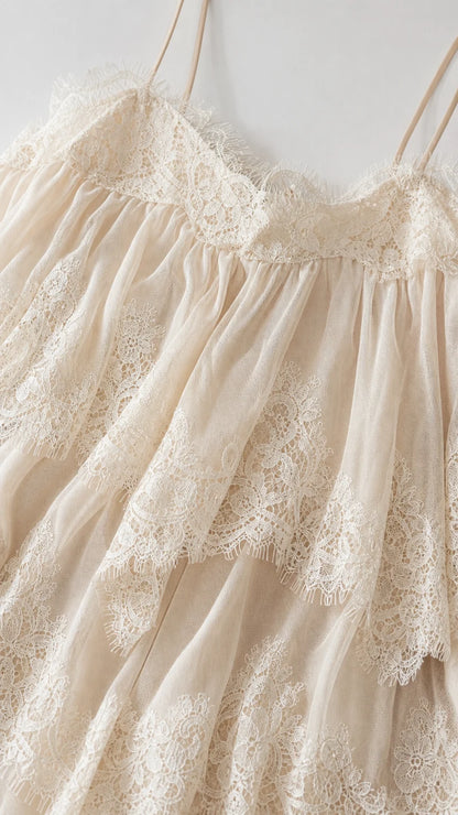 Close up of textured lace and tiered layers on cream dress