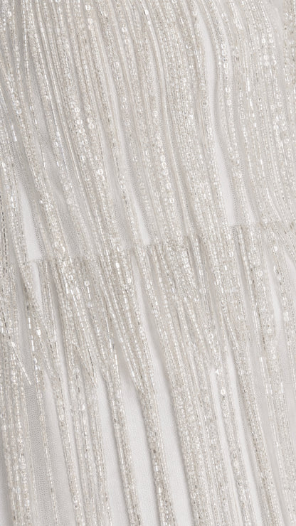 Close-up texture view of white beaded fringe fabric