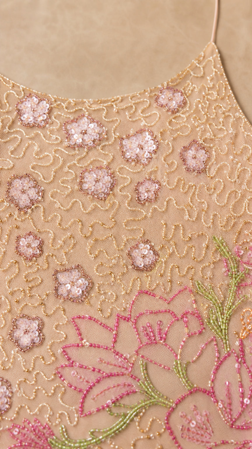 Close-up detail of sequin and bead floral embroidery on mesh overlay