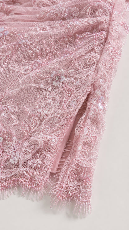 Close-up of intricate pink lace texture and scalloped hem