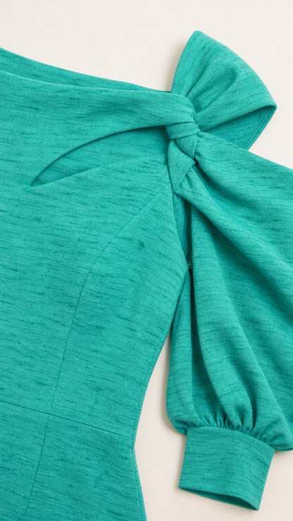 Close-up detail of the shoulder bow and textured teal fabric