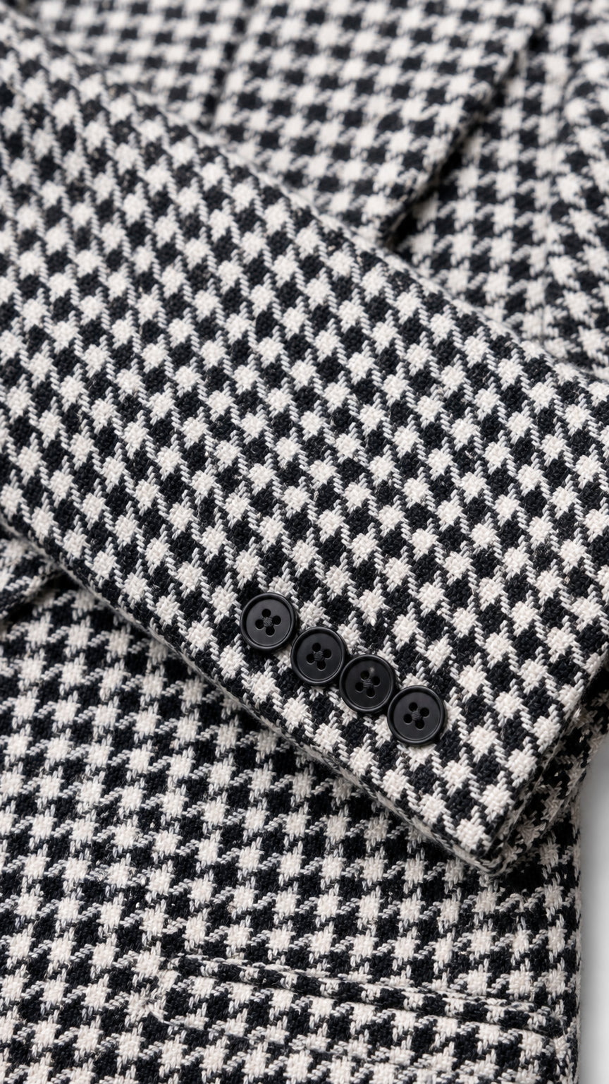 Close-up detail of houndstooth fabric and sleeve button accents
