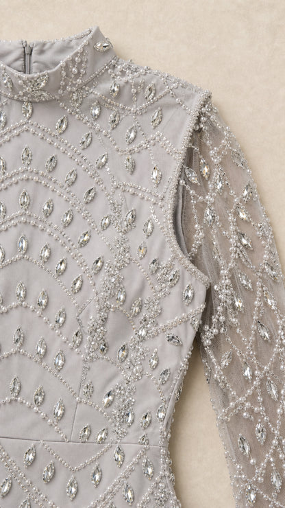 Close-up detail of rhinestone and bead pattern on silver high neck bodice