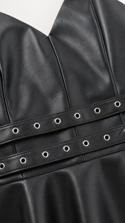 Close up of grommet waist belts on black faux leather dress