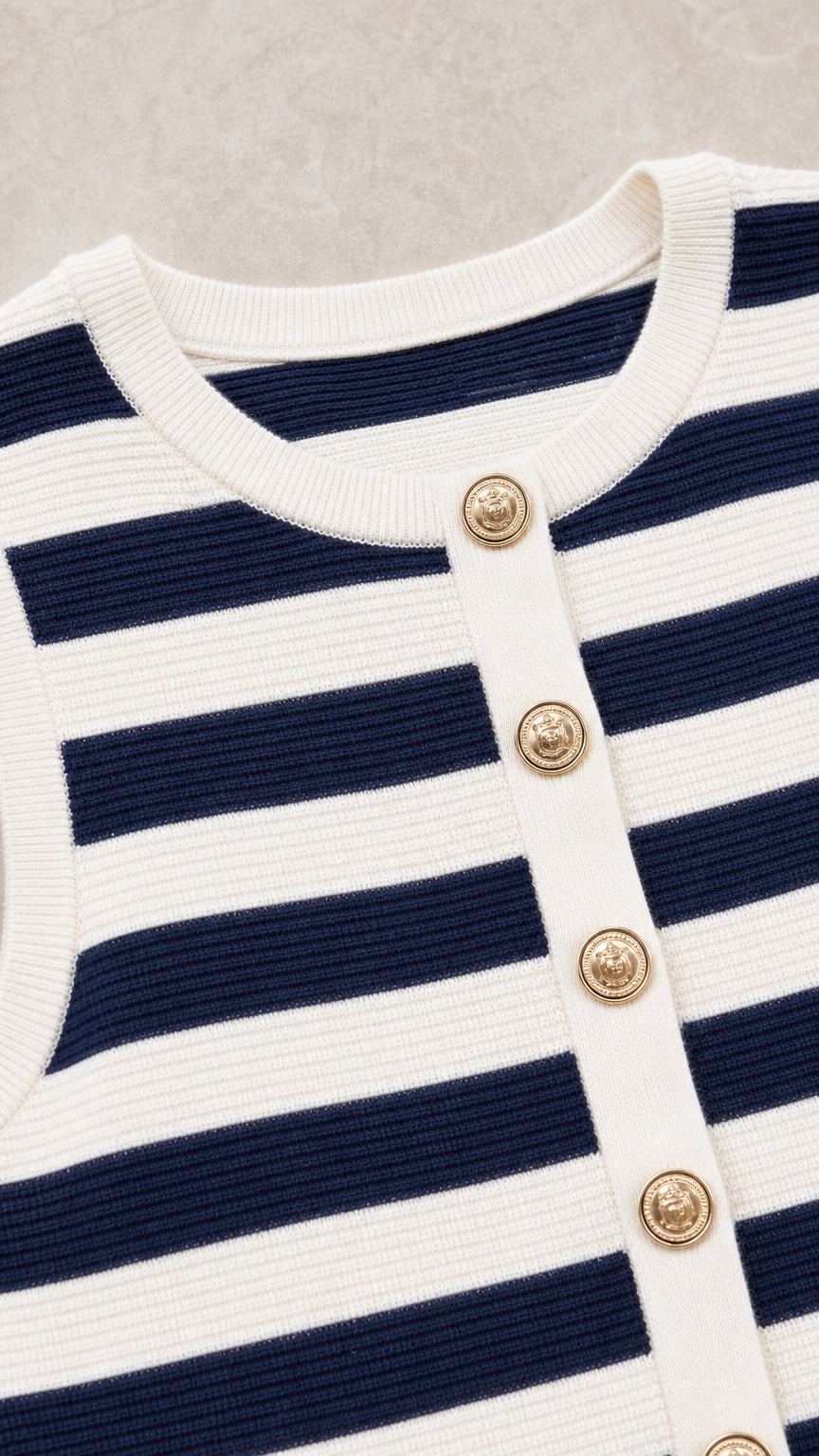 Close-up detail of neckline, gold buttons, and knit texture