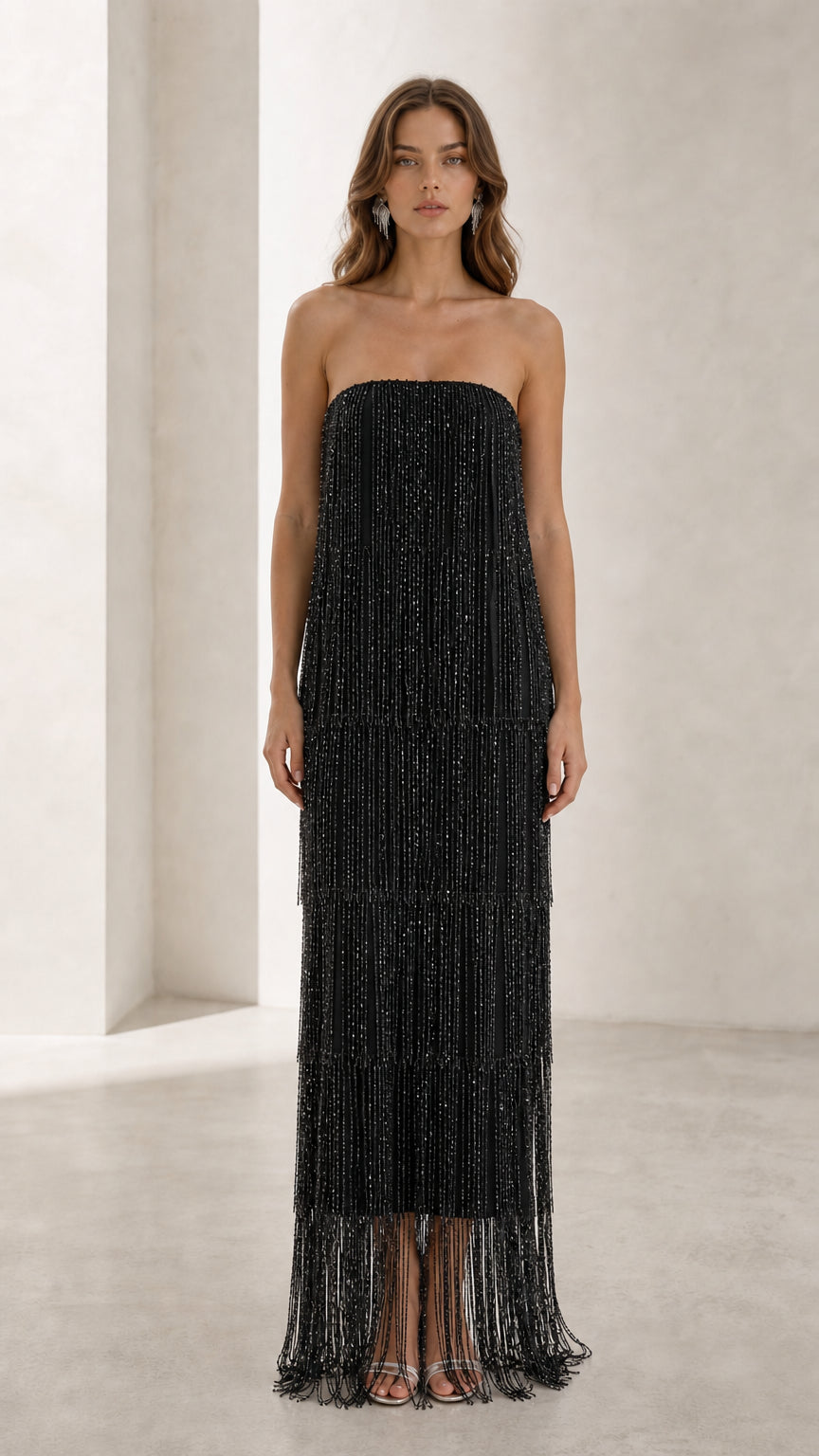 Full view of woman in black strapless beaded fringe maxi dress