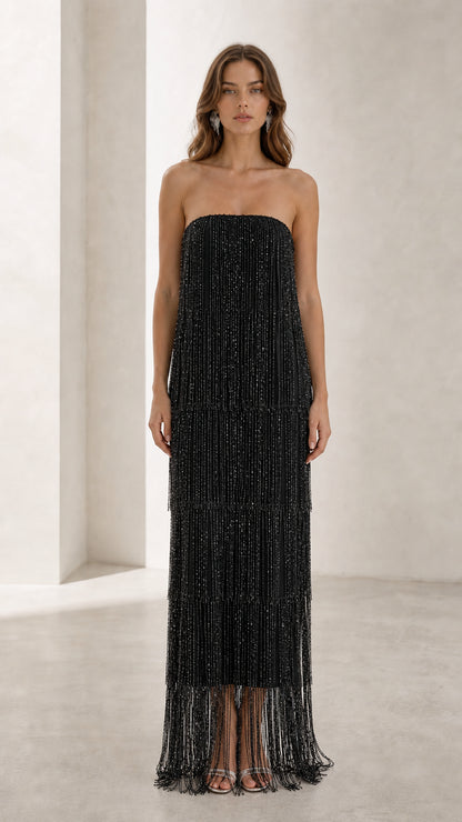 Full view of woman in black strapless beaded fringe maxi dress