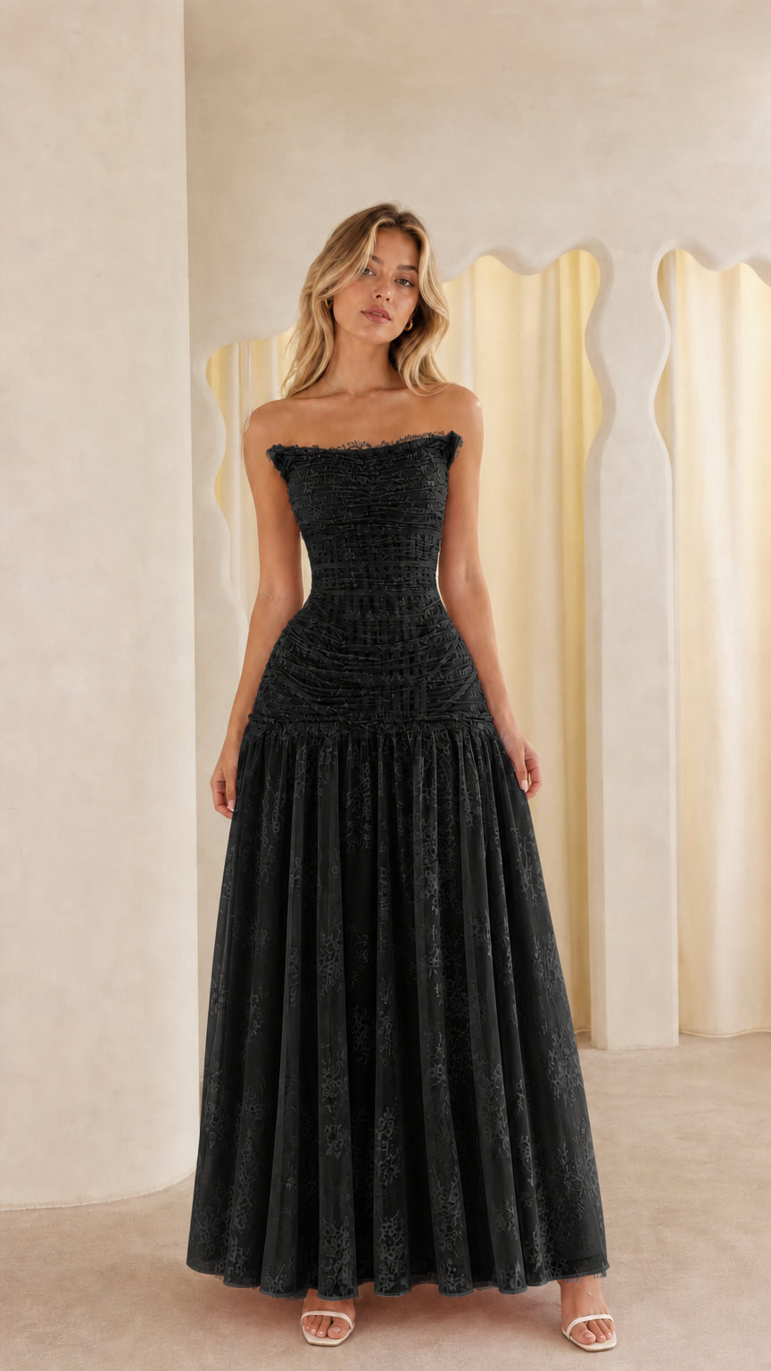 Model wearing black strapless lace maxi dress