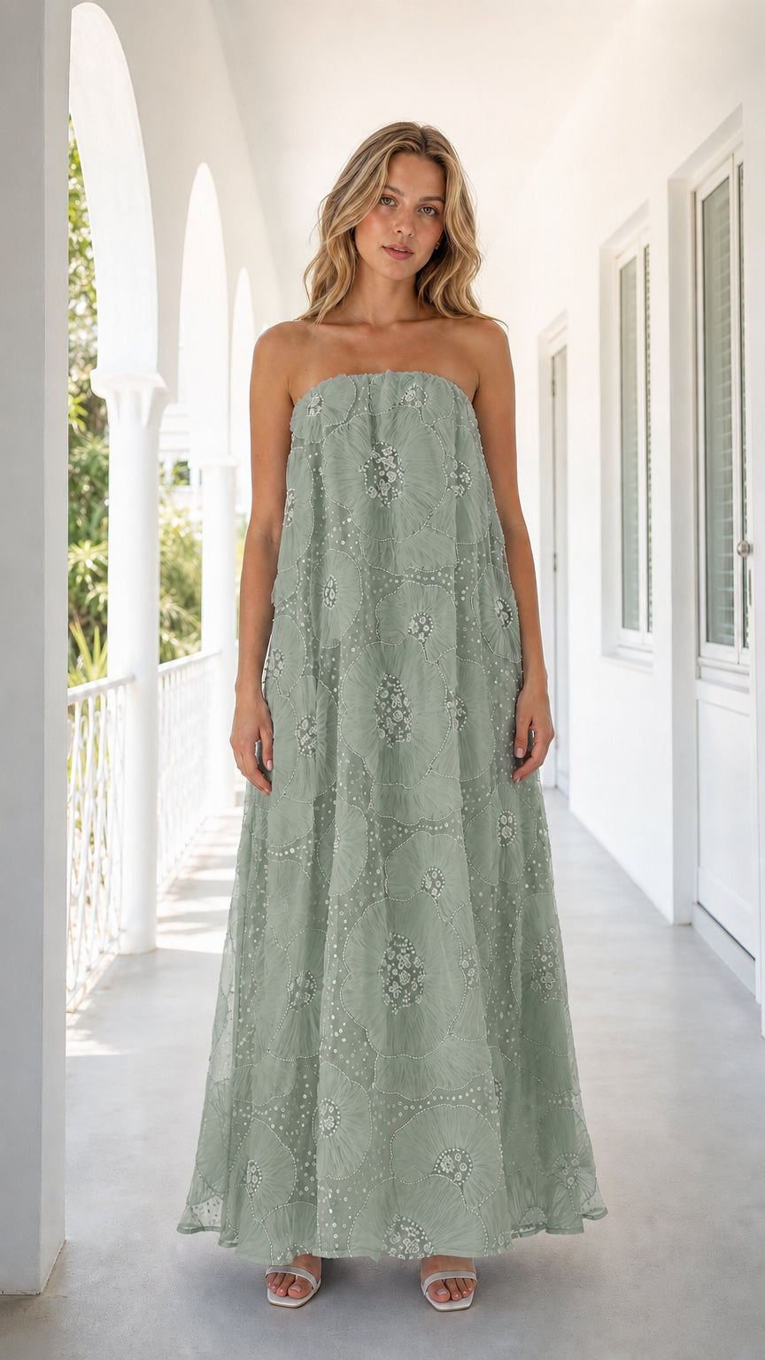 Front view of woman wearing sage green strapless embroidered floral maxi dress