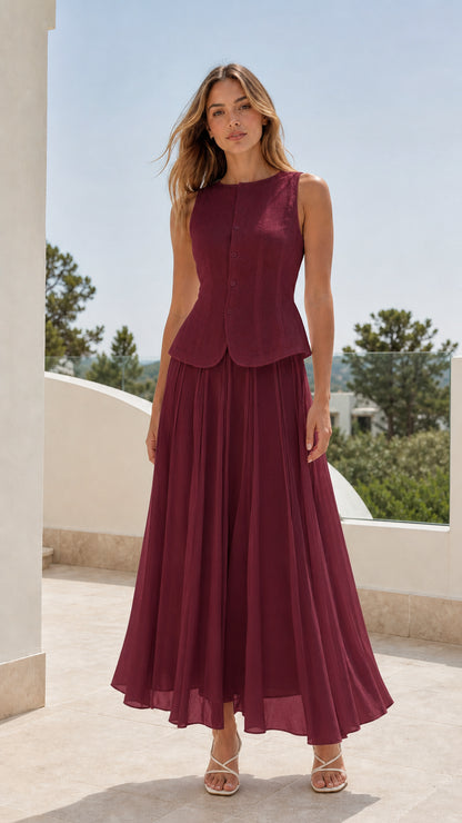 Woman wearing burgundy two-piece sleeveless blouse and pleated maxi skirt set