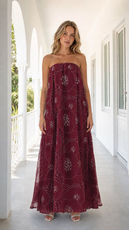 Front view of woman wearing burgundy strapless embroidered floral maxi dress