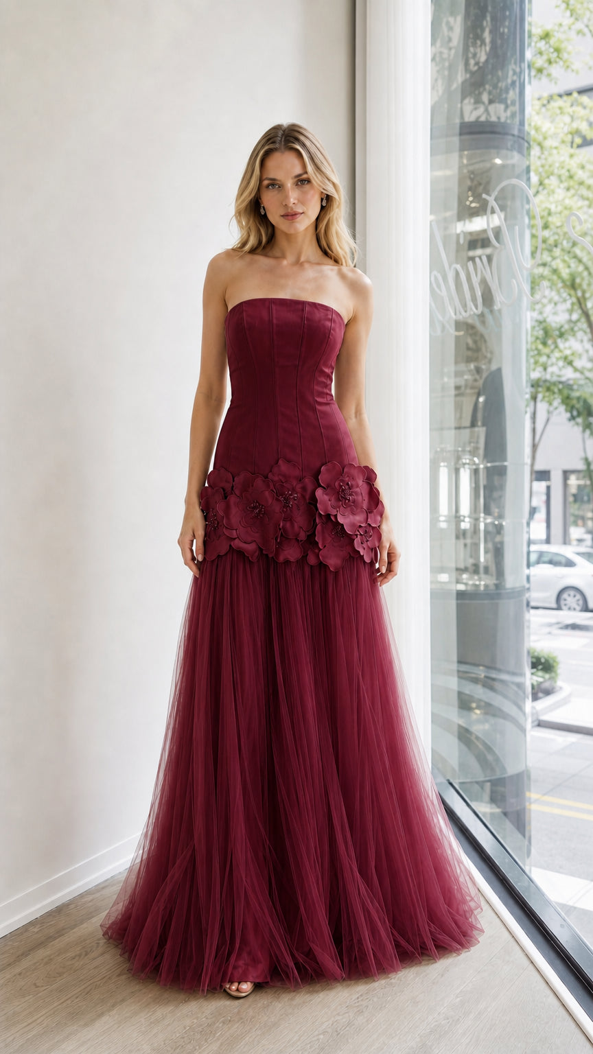 Front view of burgundy strapless evening dress with floral appliques