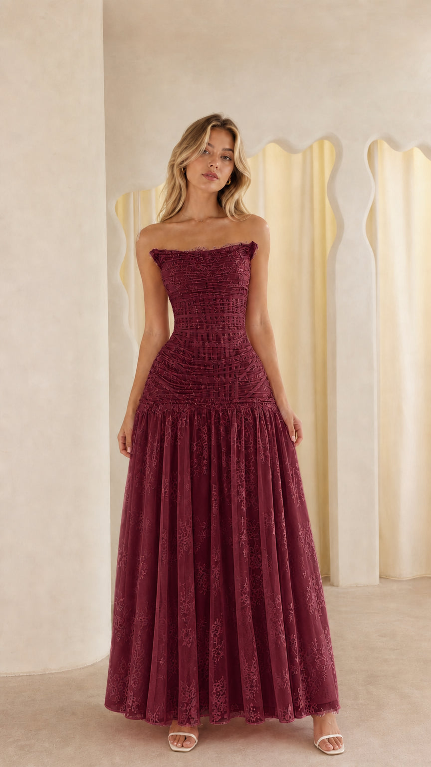 Model wearing burgundy strapless lace maxi dress